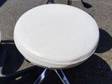 deux tabourets blancs et une chaise blanche dans la rue