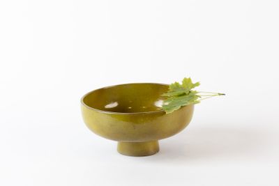 un petit bol vert orné d'un brin de persil