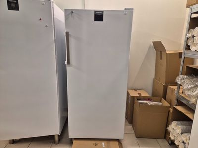 deux réfrigérateurs blancs dans une pièce où se trouvent des cartons par terre