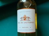 une bouteille de vin posée sur une table de billard, à côté d'un couteau