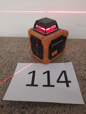 un niveau laser équipé d'un faisceau rouge et une feuille de papier posée à côté