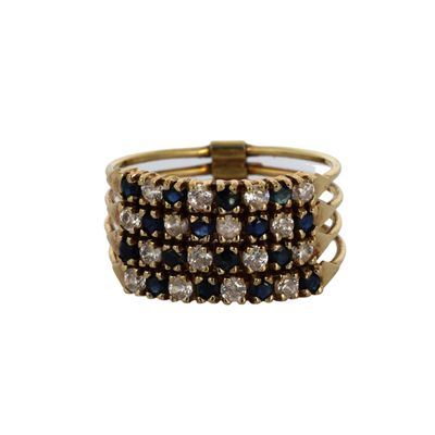 gros plan d'une bague en or avec des pierres bleues et blanches