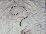 a dragon embroidered on the fabric of a bed