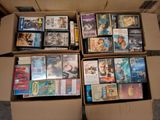 un grand nombre de DVD dans une boîte en carton posée sur le sol