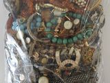 a bag of assorted jewelry on a white surface