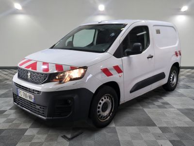 La camionnette blanche est garée dans le garage dont le sol est à carreaux.