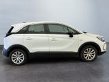 the white suv is parked in a room with a gray wall