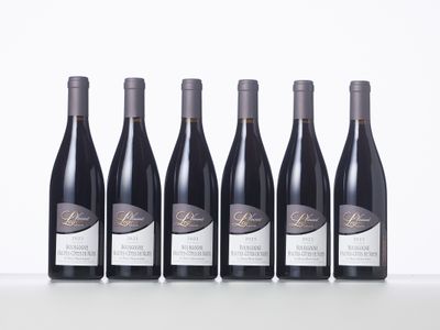 six bottles of wine lined up in a row on a table