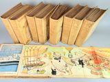 several old books are lined up on a white surface