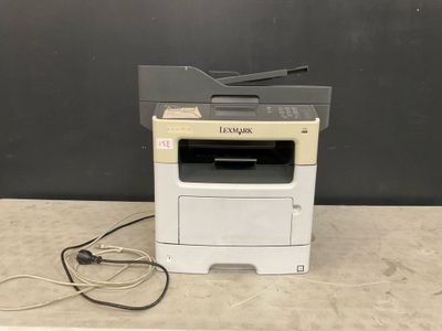 a white printer sitting on top of a counter next to a black wall