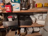 a shelf with a mixer, plates, bowls, and other items on it