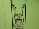 a tall iron plant stand with a vase on it