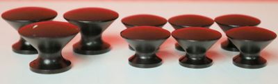 six boutons noirs sur une surface blanche avec un fond rouge