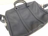 black leather handbag sitting on a white surface with a white background