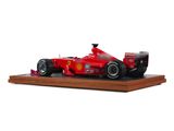 the model of a red race car is on display on a wooden stand