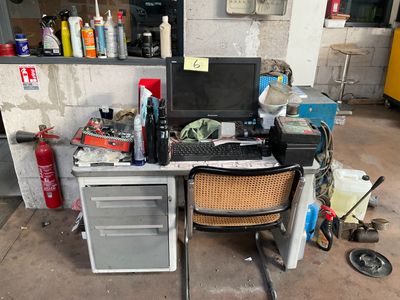 a desk with a computer on top of it in a garage