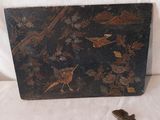 une boîte noire ornée d'un oiseau, posée sur un fond blanc
