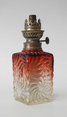 an image of a red and white glass perfume bottle on a white surface