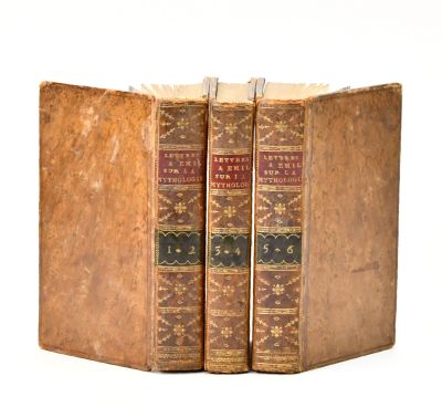 two old books sitting on top of each other on a white surface