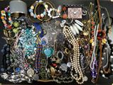 many different types of necklaces and bracelets in this case