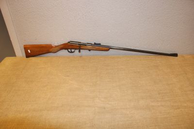 un fusil posé sur une table près d'un mur