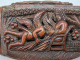 a wooden box with a carving of a man and a woman on it