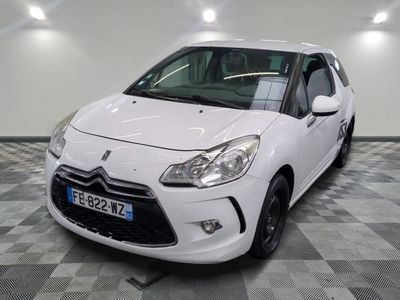la petite voiture blanche est garée sur un carrelage à carreaux