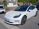 une Tesla blanche garée sur le bord de la route