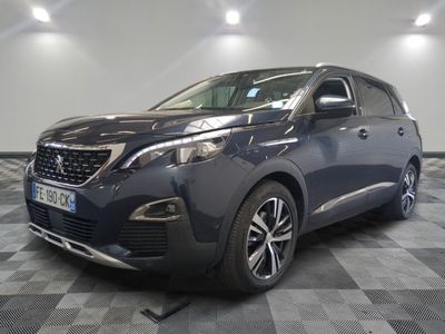 la voiture bleue est garée sur un sol en damier dans le garage