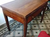 une petite table en bois avec une chaise rouge devant
