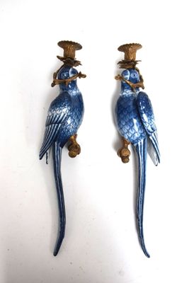 une paire de figurines de perroquets bleus posées sur une table blanche