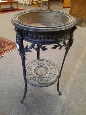 une table noire avec un plateau en verre, posée sur un sol recouvert de moquette