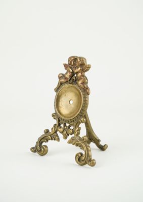 une petite horloge ornée d'un cerf, posée sur un socle
