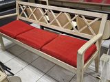 un banc blanc avec des coussins rouges dans une pièce
