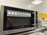Quelqu'un prend une photo d'un micro-ondes dans une cuisine.