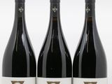 trois bouteilles de vin rouge posées sur une table blanche