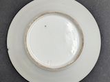 white plate with a gold rim on a gray surface