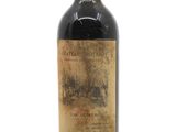 une vieille bouteille de vin posée sur une surface blanche