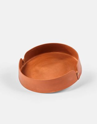 un plateau en cuir marron muni d'une poignée, sur fond blanc
