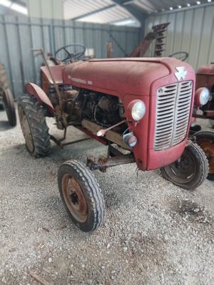 un tracteur rouge qui est garé dans la terre