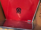 a person holding a red laptop in a box
