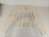 Le pull est blanc et porte une étiquette blanche.