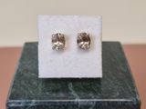 a pair of earrings sitting on top of a marble block