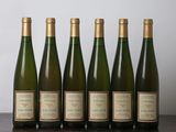 six bouteilles de vin sont alignées sur une table en bois