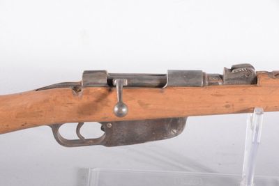 un vieux fusil au canon en bois exposé dans une vitrine