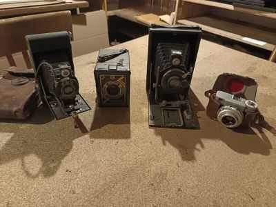 three old cameras sitting on a table next to each other