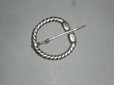 une broche en argent avec une épingle au milieu