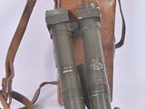 pair of binoculars with leather case and strap on a white background