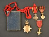 an assortment of medals and a book sit on a table
