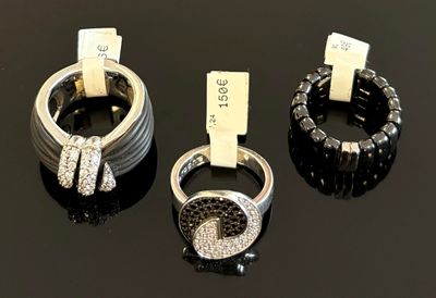 trois anneaux sertis de diamants noirs et blancs sur un fond noir